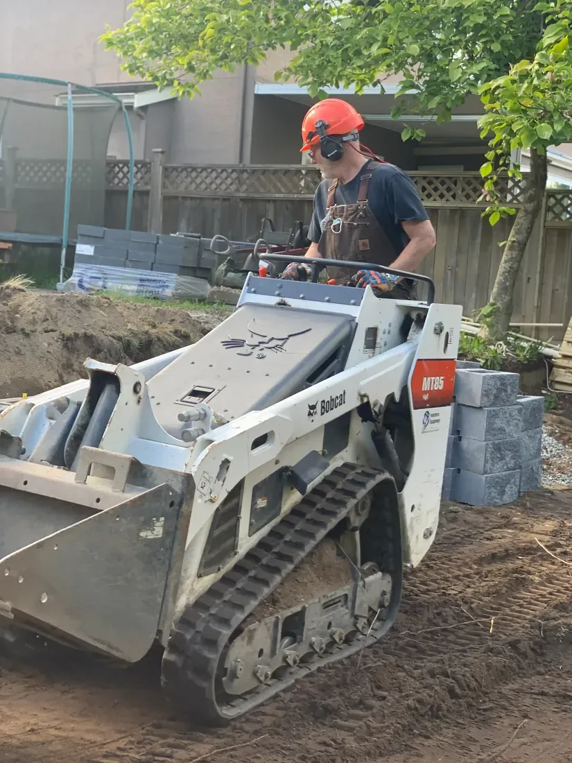Hardscape pathway repair underway with a compact loader