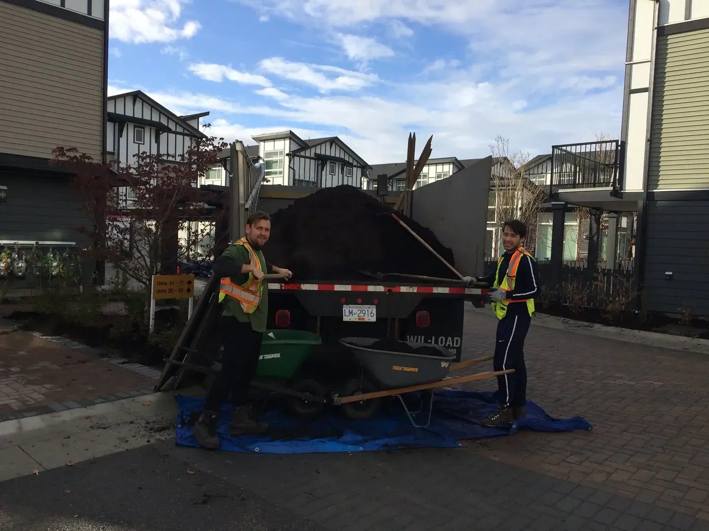 Crew unloading soil for bed top-ups at a strata property